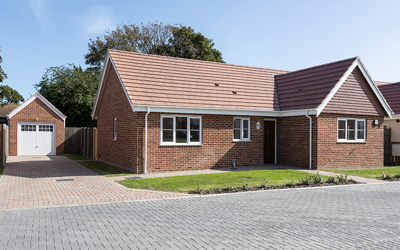 New build bungalow with blue skies and planted front garden